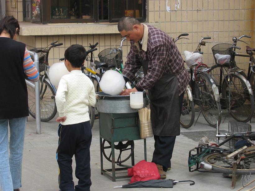 0604Sgh_IMG_2643.jpg - Un vendeur de barbe à papa à l'entrée d'un parc de Shanghai. La machine est actionnée au pied.